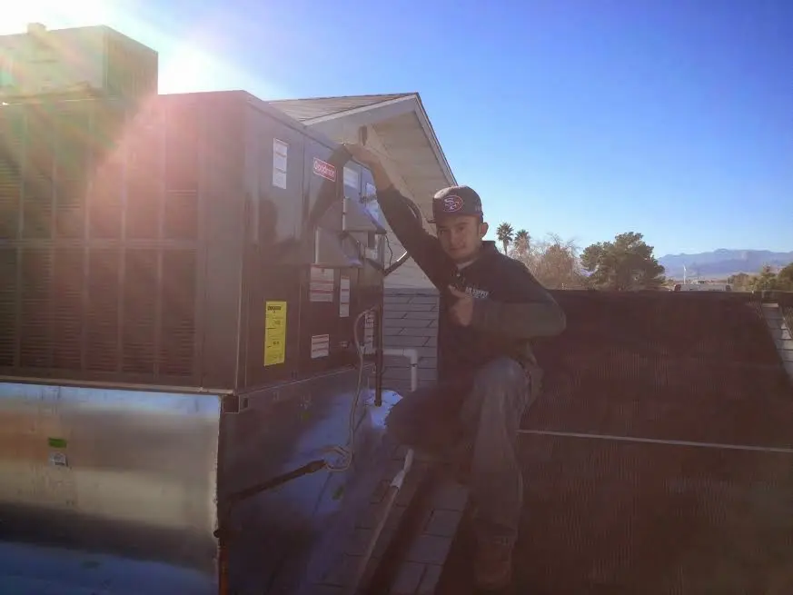 HVAC technician performing AC Tune-Up on a rooftop unit in Olivehurst